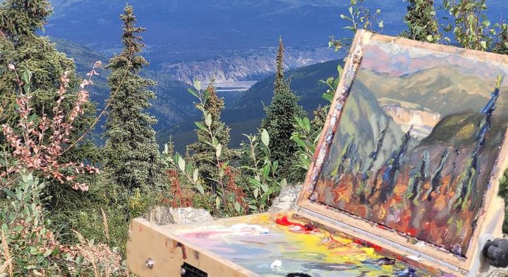 Landscape painting set up outdoors on easel